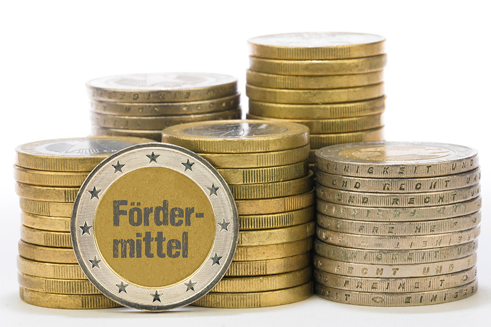 Symbolbild Fördermittel Gestapelte Euro-Münzen, auf denen Fördermittel steht statt Zahlen