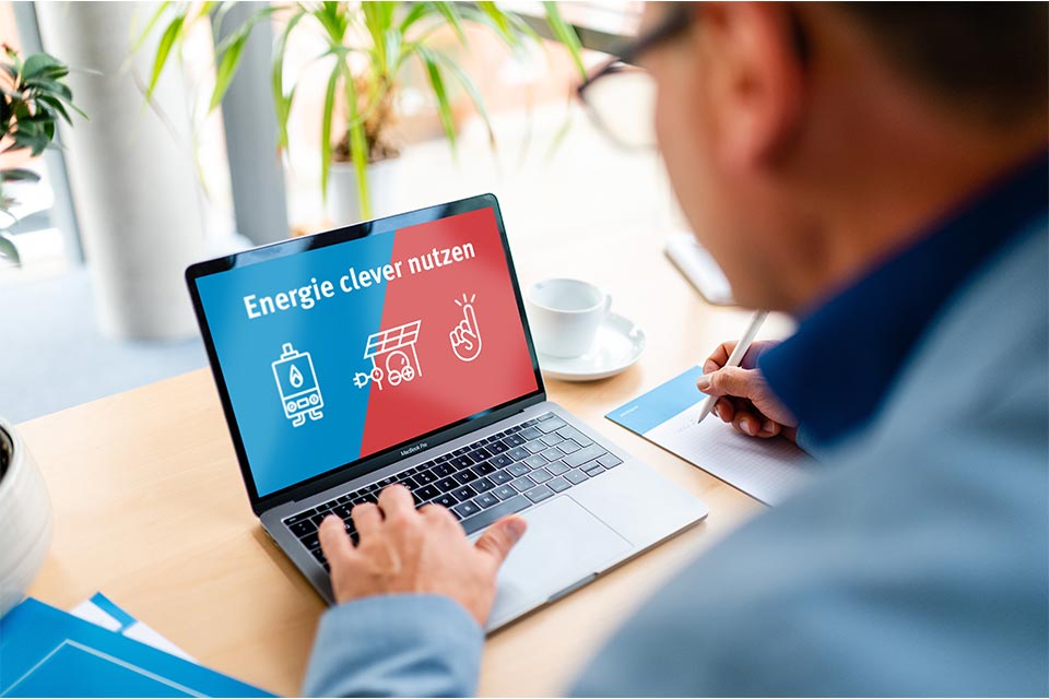 Online-Energieberatung am Laptop Mann schaut auf aufgeklappten Laptop