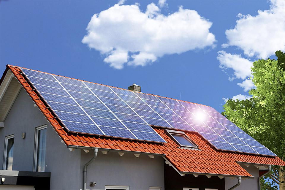 Solaranlage auf dem Dach eines Einfamilienhauses Sonne spiegelt sich auf der Solaranalge auf dem Dach eines Einfamilienhauses