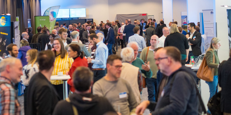 Ausstellung ThEGA-Forum 2024 Ein Raum mit ca. 250 Menschen, leicht von oben fotografiertm zeigt die Ausstellung von Thüringer Firmen auf dem ThEGA-Forum 2024