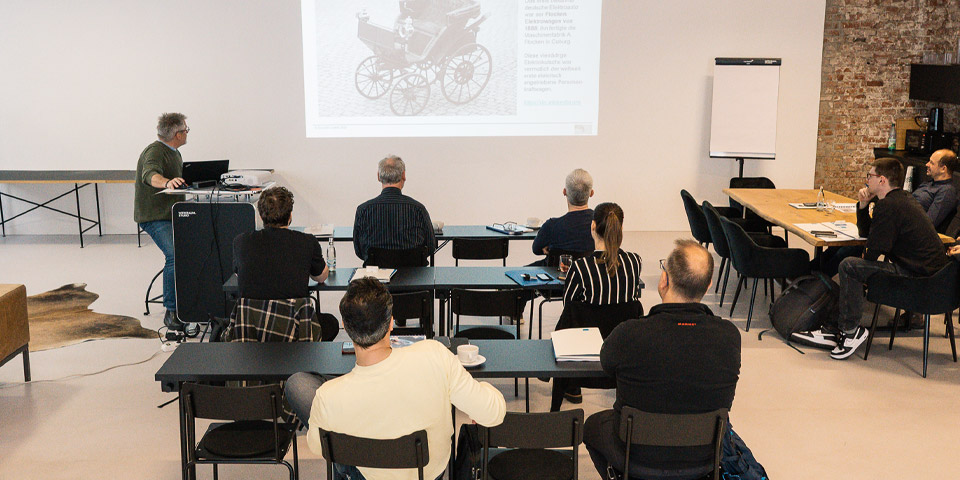 Gruppe verfolgt gespannt eine Präsentation kleine Gruppe von ca. 9 Personen verfolgt gespannt eine Präsentation. Szene wurde von hinten fotografiert